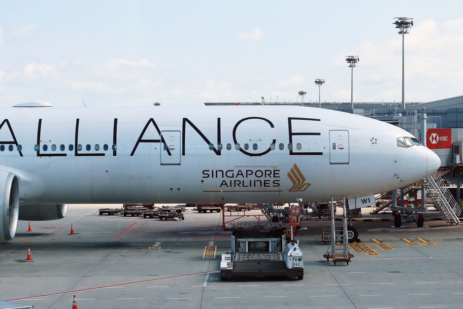 Singapore Airlines airplane parked at an airport gate ready for departure.