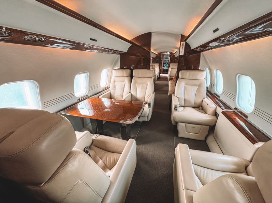 Luxurious interior of a private jet showcasing leather seating and elegant wooden trim.
