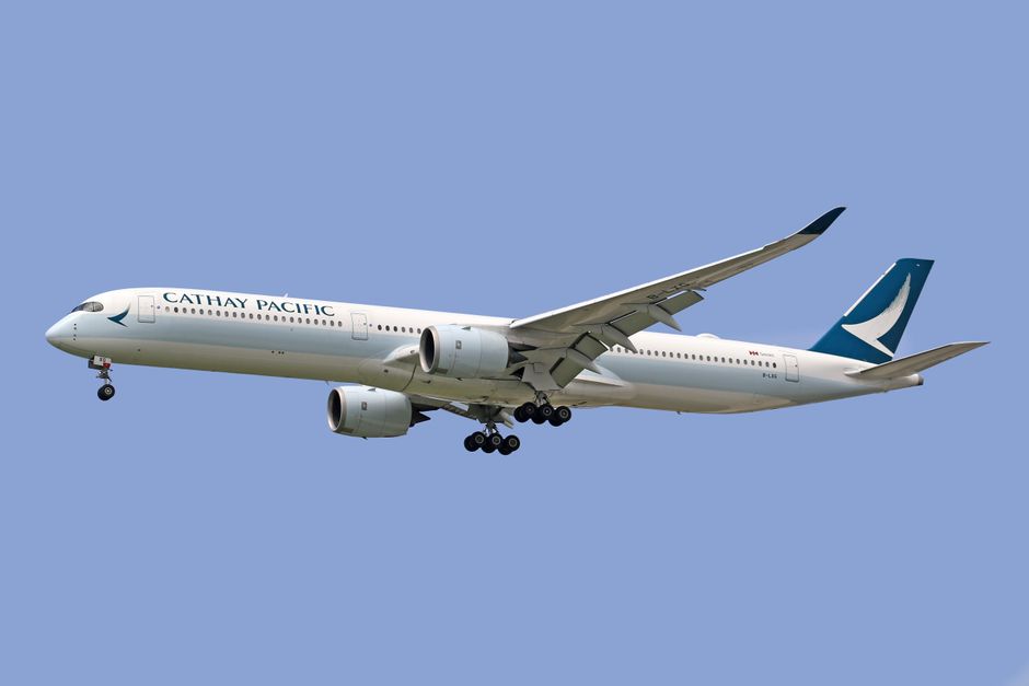 Cathay Pacific Airbus A350 flying against a clear blue sky.