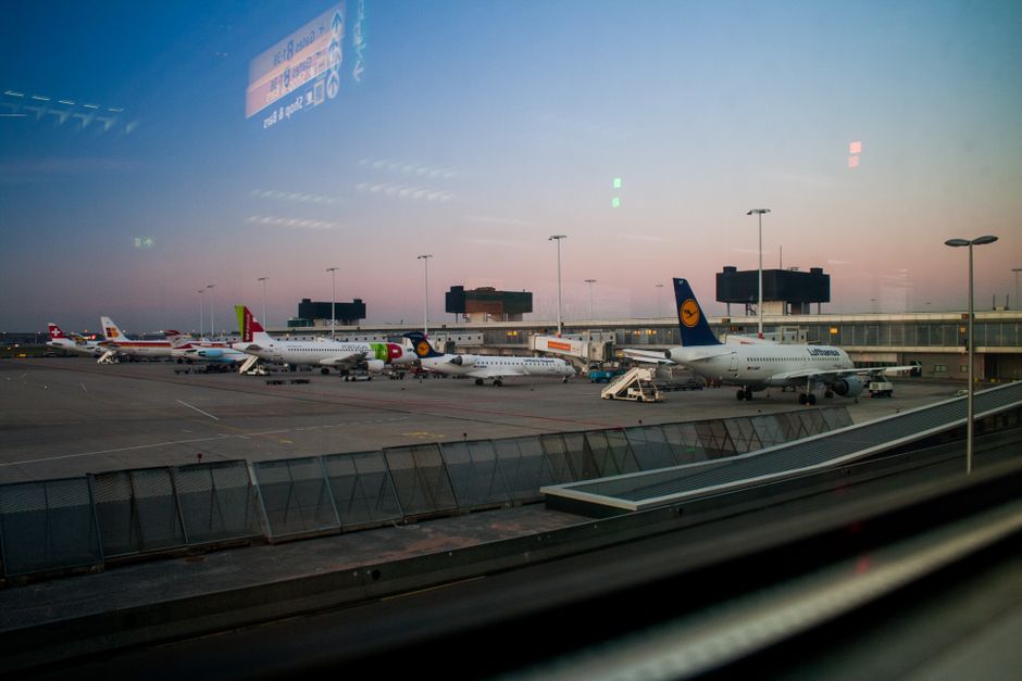 View of various airplanes parked at an airport during dusk, showcasing aviation.