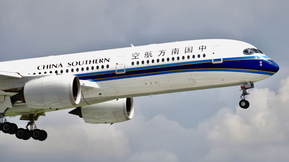 Close-up of a China Southern Airlines airplane flying with clear skies in the background.