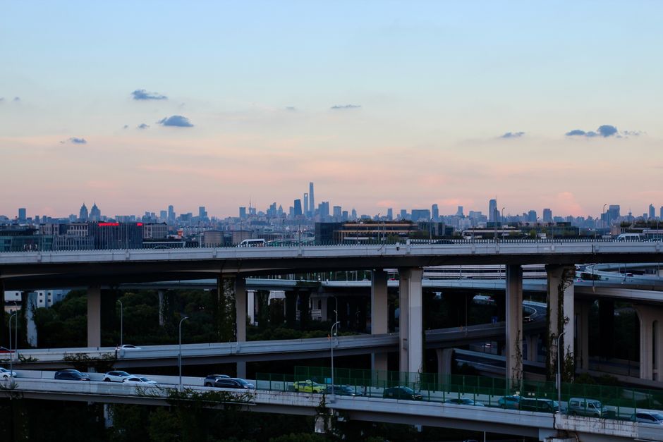 A multi-level highway overlooking a distant city skyline at dusk, capturing urban life.