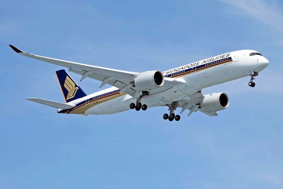 A Singapore Airlines Airbus A350 jet under a clear blue sky, showcasing its landing gear.
